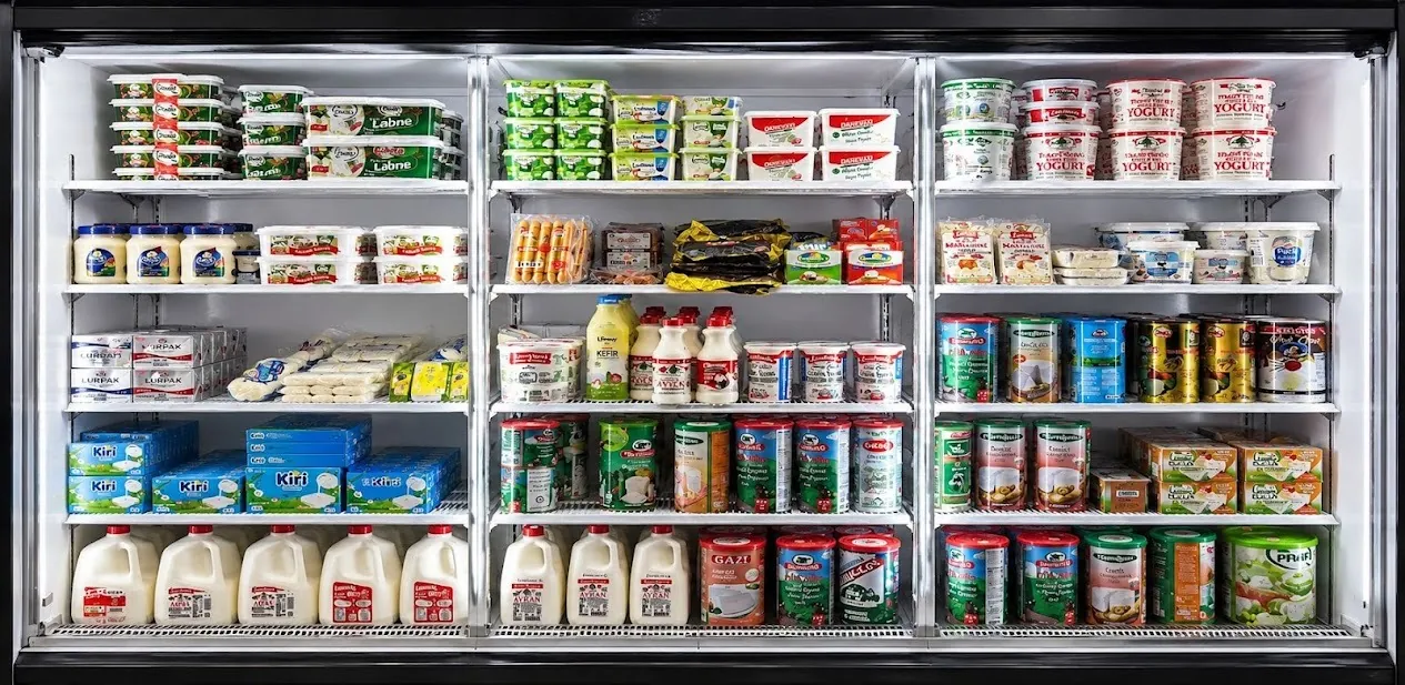Dairy refrigerator stocked with labneh, cheese, and milk