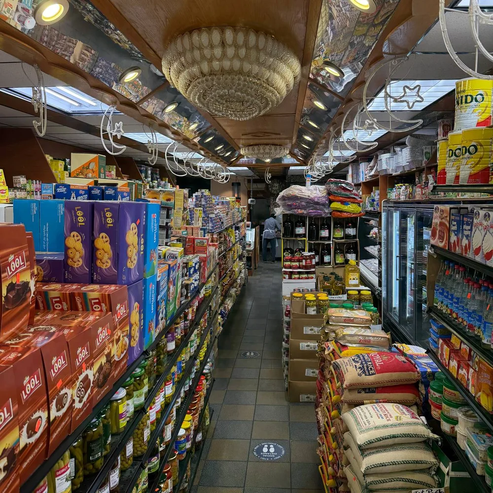 Inside Bay Root Meats — international grocery aisles with chandeliers and stocked shelves