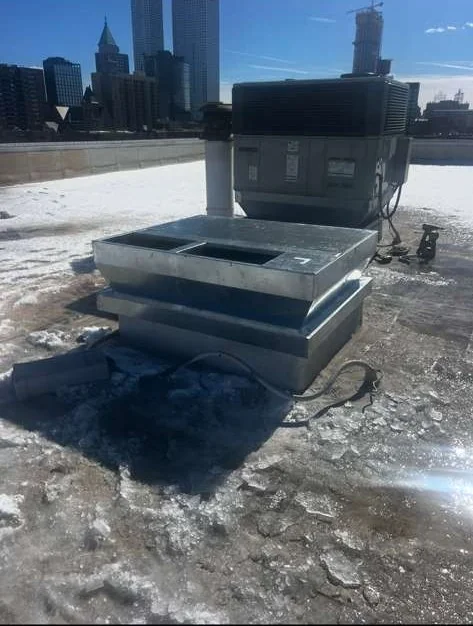 Commercial rooftop HVAC unit with winter city skyline
