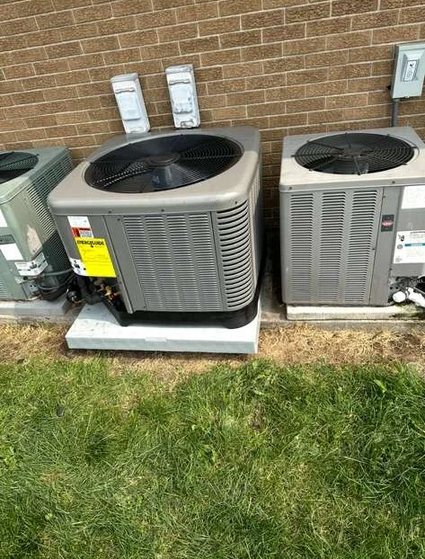 Multiple residential AC condenser units on a pad